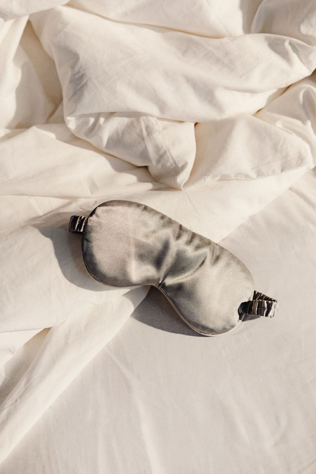 Silk sleep mask on white bedding